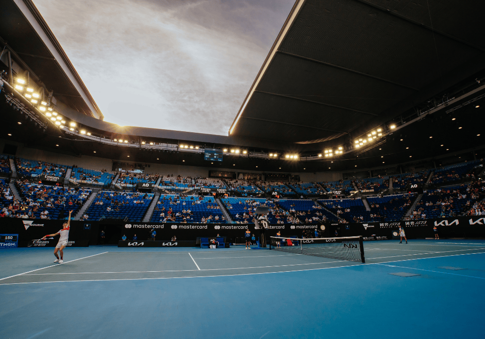australian open blue tennis court with a view of the audience and sunset in the background